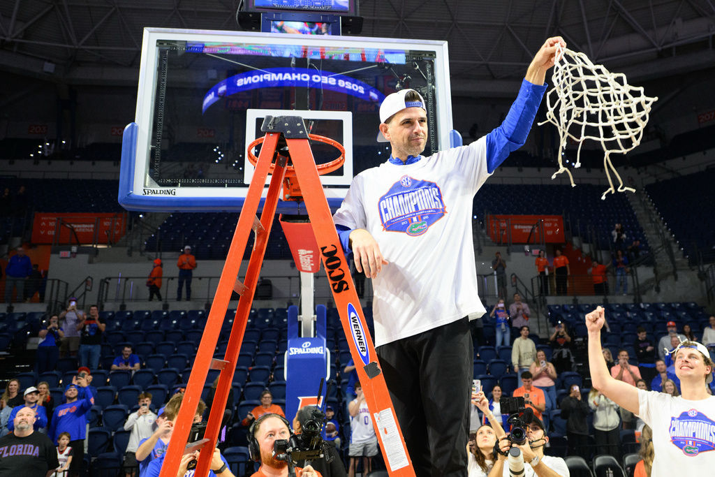 Florida head coach Todd Golden holds the net after clinching the SEC regular season championship after an NCAA college basketball game against Arkansas, Saturday, Feb. 28, 2026, in Gainesville, Fla. (AP Photo/Noah Lantor)