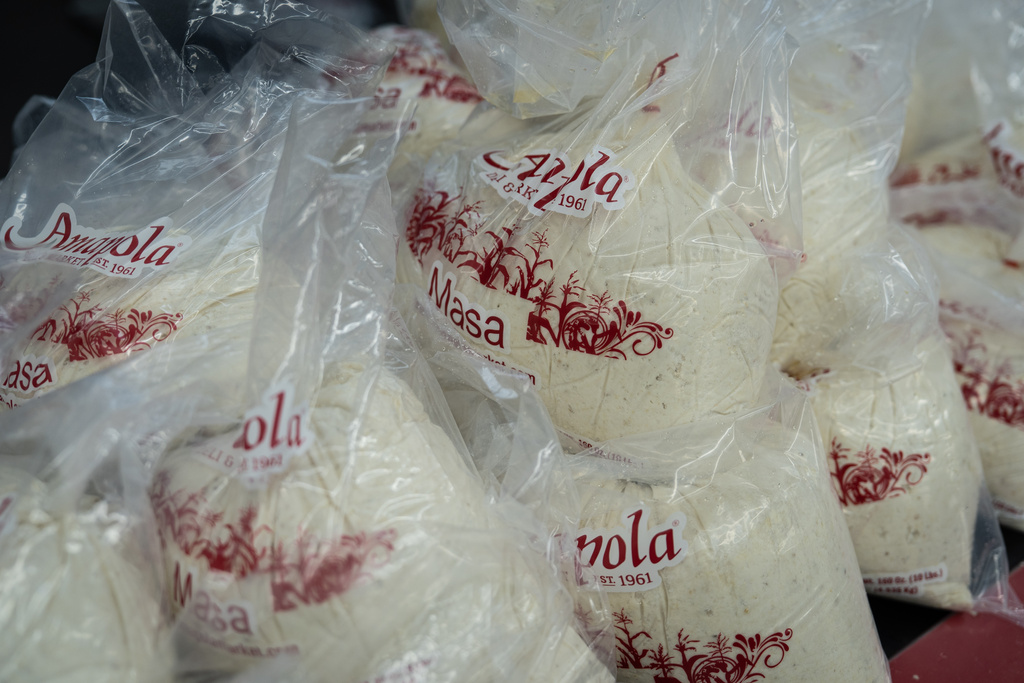Bags of masa, a dough used to make tamales, are stacked on a counter at Amapola Market in Downey, Calif., Tuesday, Dec. 23, 2025. (AP Photo/Jae C. Hong)