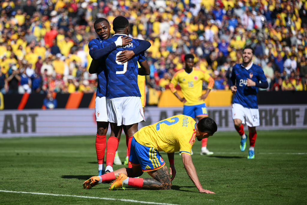 France forward Marcus Thuram (9) is embraced by Pierre Kalulu (5) after scoring his side's second goal during the international friendly soccer match between Colombia and France in Landover, Md., Sunday, March 29, 2026. (AP Photo/Nick Wass)