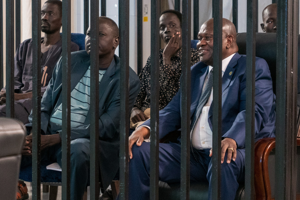 FILE- South Sudan's suspended First Vice President Riek Machar, right, sits in the dock with seven others charged with murder, treason, and crimes against humanity at the Freedom Hall in Juba, South Sudan, Wednesday, Sep. 24, 2025. (AP Photo/Florence Miettaux, file)