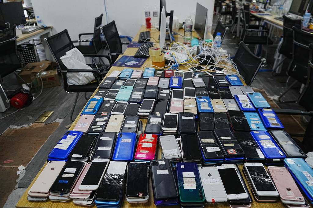 Equipment confiscated in a raid by Cambodian police are laid out on a table at a scam center in Phnom Penh, Cambodia, Wednesday, March 11, 2026. (AP Photo/Heng Sinith)