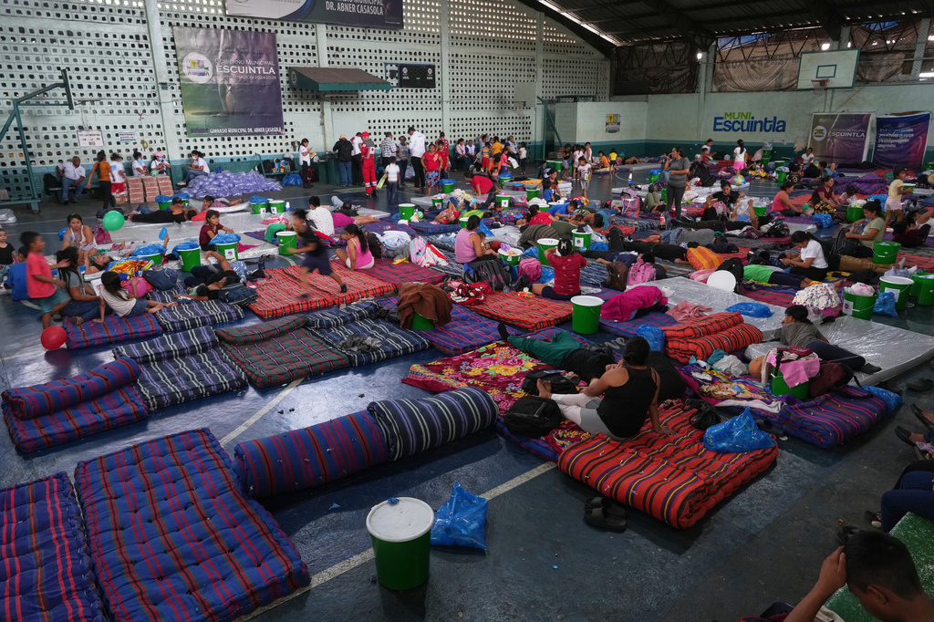 Residents evacuated from El Porvenir, a village on the slopes of the Fuego volcano, gather in a temporary shelter in Escuintla, Guatemala, Tuesday, Aug. 4, 2026. (AP Photo/Moises Castillo)