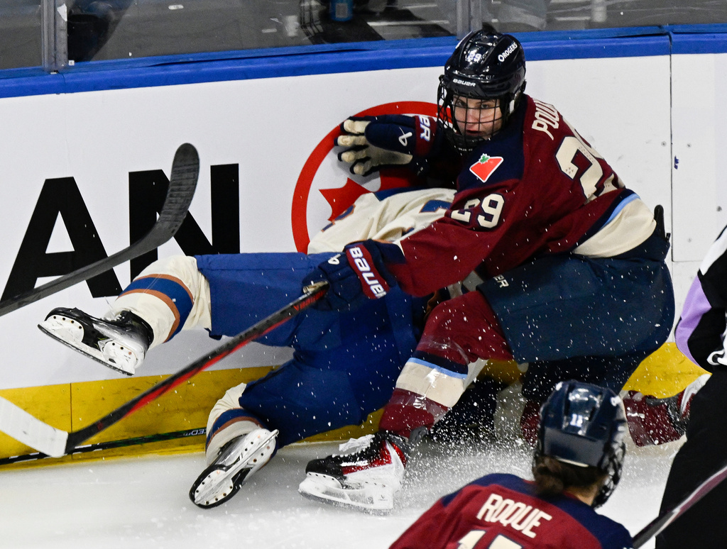 Montreal Victoire's Marie Philip Poulin (29) and Vancouver Goldeneyes' Darcie Lappan, left, collide while chasing the puck during first-period PWHL hockey game action in Quebec City, Sunday, Jan. 11, 2026. (Jacques Boissinot/The Canadian Press via AP)