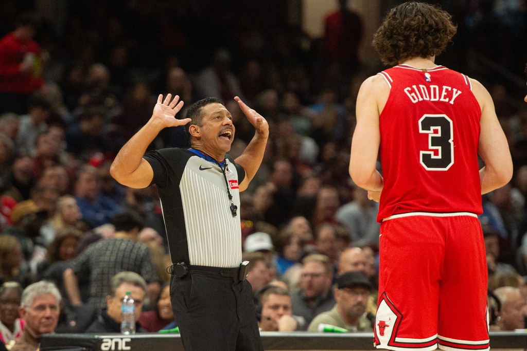 Referee Bill Kennedy, left, explains a foul call to Chicago Bulls' Josh Giddey (3) during the first half of an NBA basketball game against the Cleveland Cavaliers in Cleveland, Saturday, Nov. 8, 2025. (AP Photo/Phil Long)