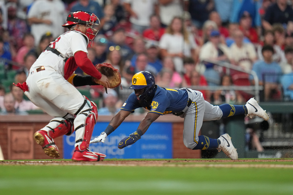Milwaukee Brewers' Luis Lara, right, scores past St. Louis Cardinals catcher Iván Herrera during the seventh inning in the second game of a baseball doubleheader Tuesday, July 7, 2026, in St. Louis. (AP Photo/Jeff Roberson)