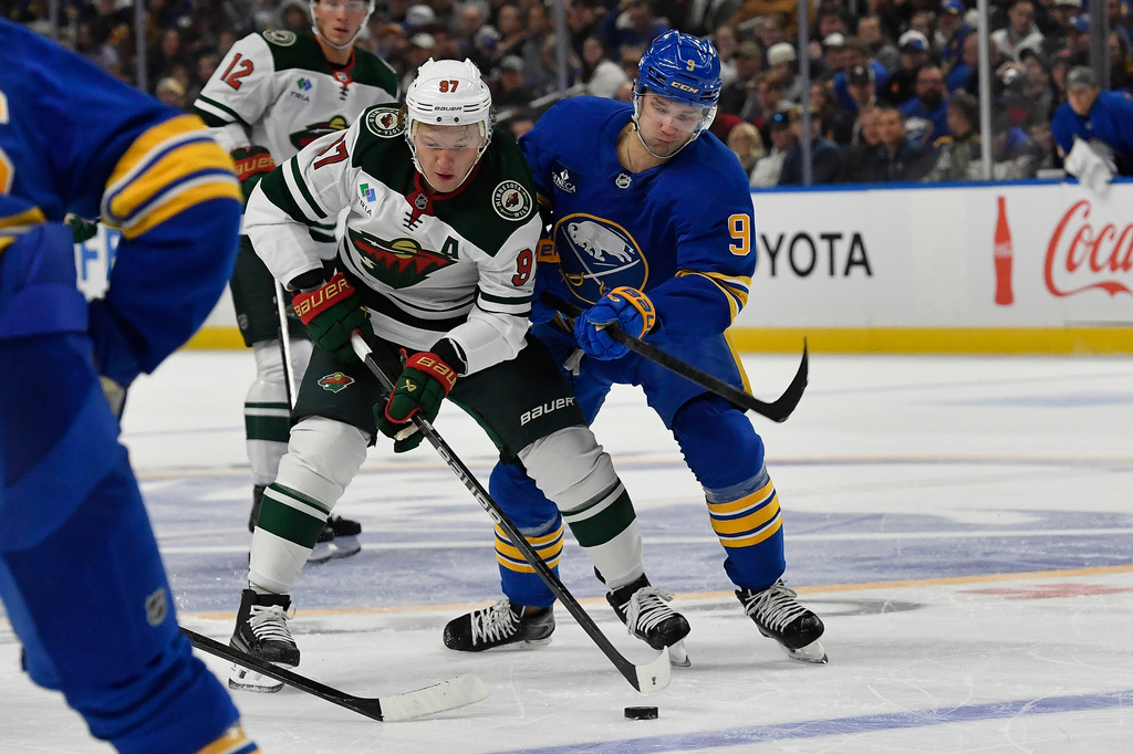 Minnesota Wild left wing Kirill Kaprizov, left, is defended by Buffalo Sabres center Josh Norris during the second period of an NHL hockey game Tuesday, Oct. 6, 2026, in Buffalo, N.Y. (AP Photo/Adrian Kraus)