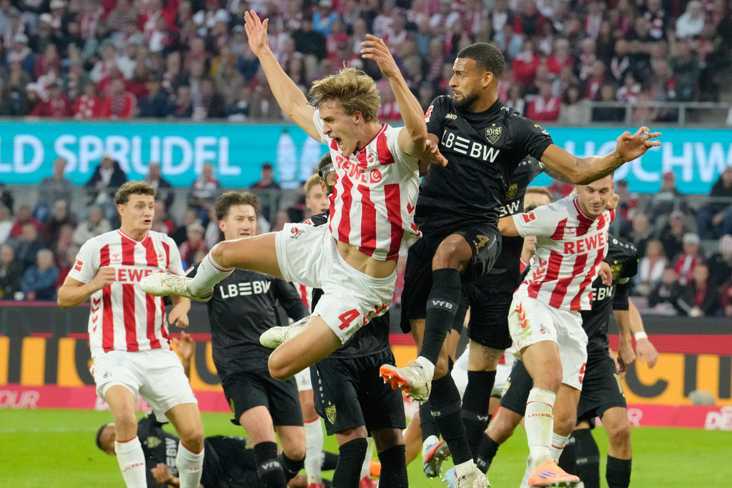 Cologne's Timo Huebers challenges with Stuttgart's Josha Vagnoman during the German Bundesliga soccer match between 1.FC Köln and VfB Stuttgart in Cologne, Germany, Sunday, Sept. 28, 2025. (AP Photo/Martin Meissner)
