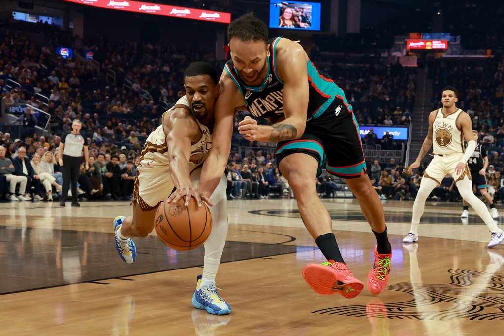 Memphis Grizzlies forward Kyle Anderson, right, and Golden State Warriors guard De'anthony Melton, left, reach for a loose ball during the first half of an NBA basketball game in San Francisco, Monday, Feb. 9, 2026. (AP Photo/Jed Jacobsohn)