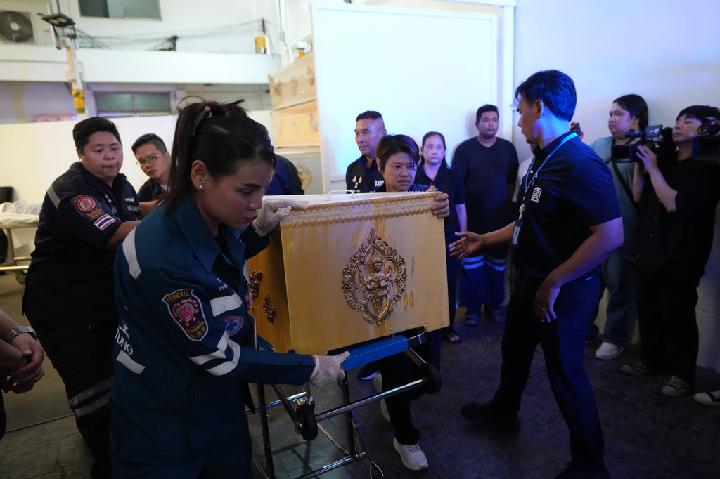 A coffin containing the body of a victim of Friday's shooting at the Debsirin Nonthaburi School, is brought in a stretcher at a police hospital in Bangkok,Thailand, Saturday, Aug. 8, 2026. (AP Photo/Sakchai Lalit)
