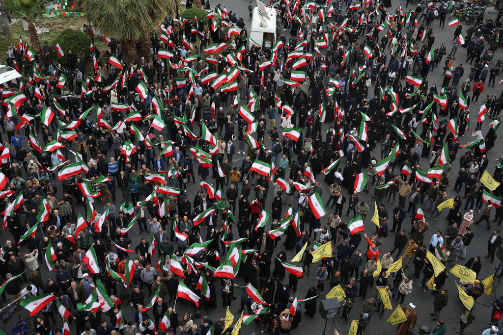 Demonstrators wave Iranian flags in a demonstration in support of the government and against U.S. and Israeli strikes in Tehran, Iran, Saturday, Feb. 28, 2026. (AP Photo/Vahid Salemi)