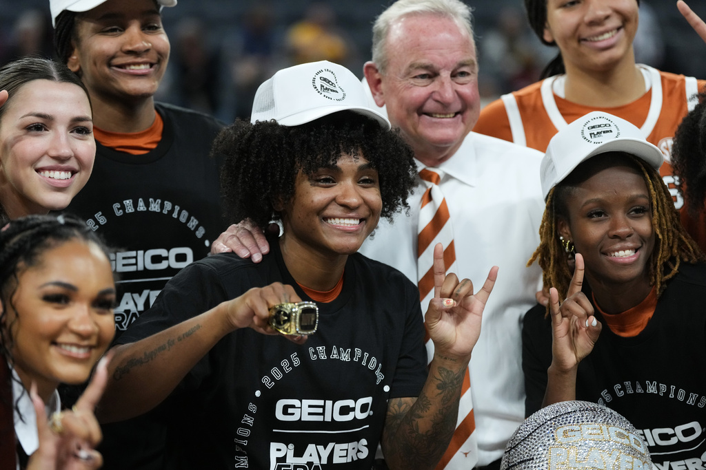 Texas guard Rori Harmon (3) holds her MVP trophy as she and teammates celebrate their win over South Carolina in an NCAA college basketball game in the Players Era tournament in Las Vegas, Thursday, Nov. 27, 2025. (AP Photo/Eric Gay)