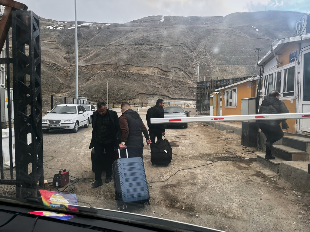 Travelers arriving from Iran carry bags at the Kapikoy border checkpoint, Turkey, Thursday, April 9, 2026. (AP Photo/Francisco Seco)