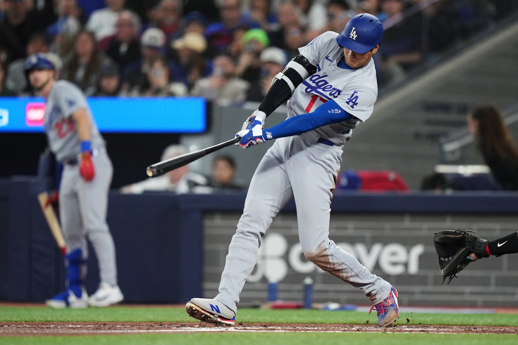 Los Angeles Dodgers' Shohei Ohtani (17) hits an RBI single against the Toronto Blue Jays during the third inning of a baseball game in Toronto, Tuesday, April 7, 2026. (Nathan Denette/The Canadian Press via AP)