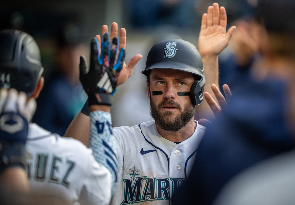 Seattle Mariners' Patrick Wisdom is congratulated by teammates in the dugout after scoring a run during the fourth inning of a baseball game against the New York Mets, Tuesday, June 2, 2026, in Seattle. (AP Photo/Stephen Brashear)