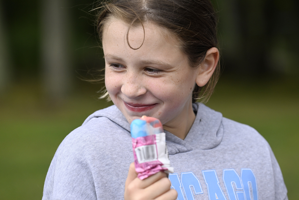 Rozzy Constant enjoys an ice cream from the Norwich Police Department Ice Cream truck in Norwich, Conn., on Thursday, Aug. 21, 2025. (AP Photo/Jessica Hill)
