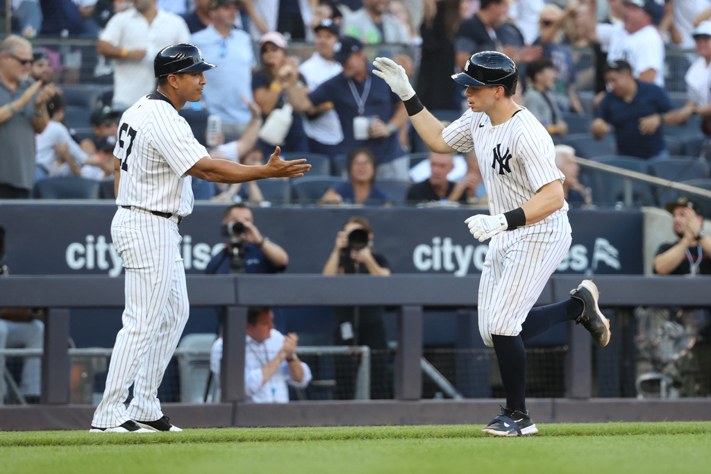 New York Yankees' Ben Rice, right, and third base coach Luis Rojas, left, react after Rice hit a home run during the eighth inning of a baseball game against the Baltimore Orioles, Sunday, Sept. 28, 2025, in New York. (AP Photo/Pamela Smith)