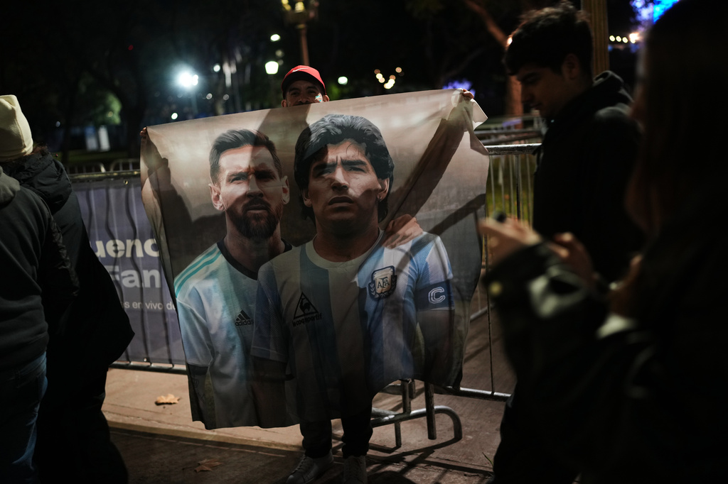 A fan holds a poster of soccer stars Lionel Messi and Diego Maradona after watching the World Cup soccer match between Argentina and Algeria in Buenos Aires, Argentina, Tuesday, June 16, 2026. (AP Photo/Rodrigo Abd)