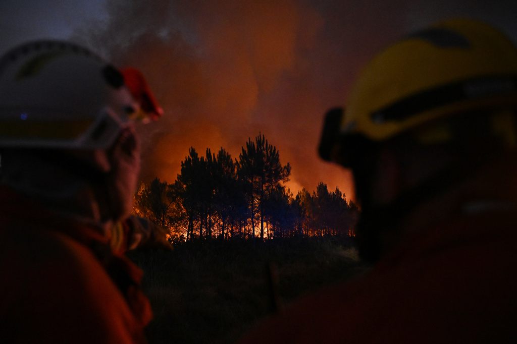 Firefighters battle a blaze outside Lanton, during wildfires in southwestern France, Tuesday, July 28, 2026. (AP Photo/Emma Da Silva)