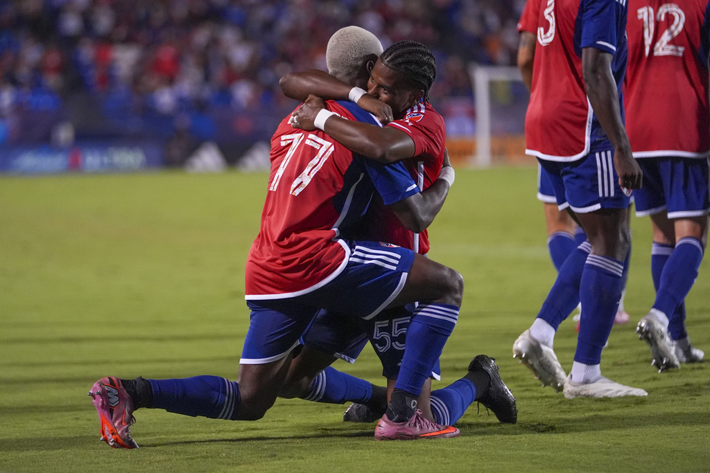 FC Dallas forward Bernard Kamungo (77) is congratulated by Kaick after scoring a goal on Nico van Rijn during the second half of an MLS soccer match Saturday, Sept. 13, 2025, in Frisco, Texas. (AP Photo/Julio Cortez)