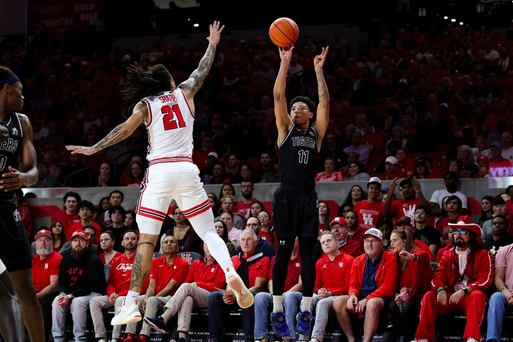 Jackson State Tigers guard Mike Williams (11) attempts shoots a three point basket as Houston Cougars guard Emanuel Sharp (21) defends during first half of an NCAA college basketball game, Wednesday, Dec 10, 2025, in Houston. (AP Photo/Maria Lysaker)
