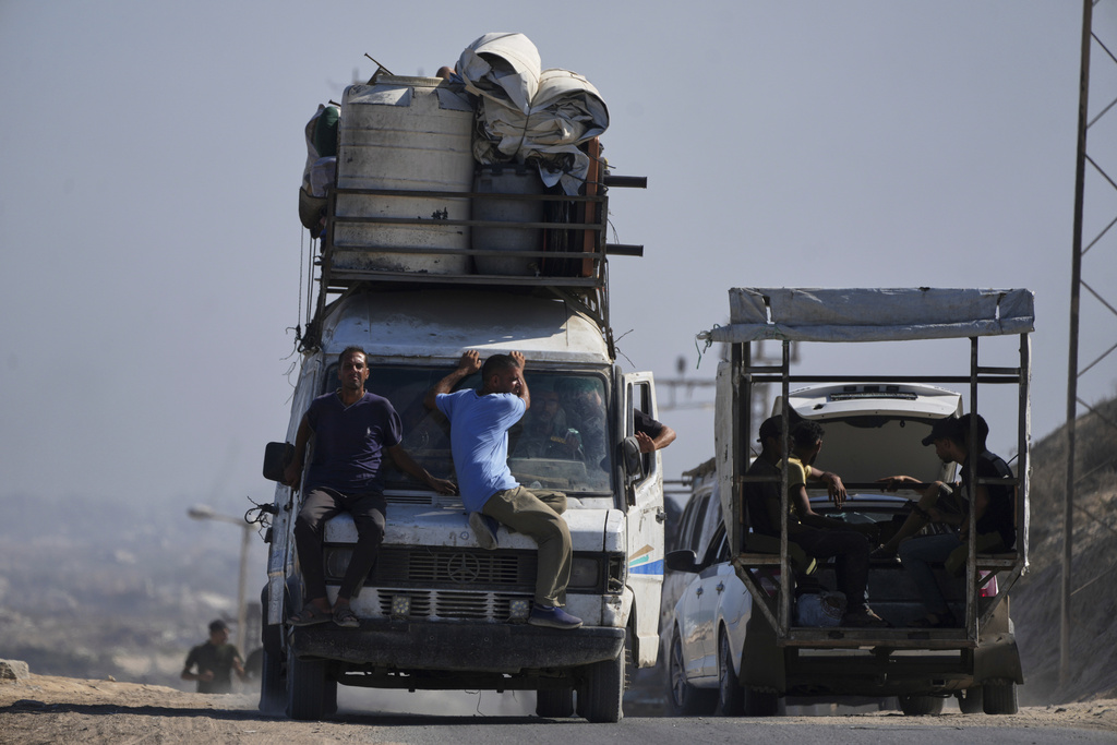 Displaced Palestinians fleeing northern Gaza carry their belongings along the coastal road toward southern Gaza, Tuesday, Sept. 9, 2025, after the Israeli army issued evacuation orders from Gaza City. (AP Photo/Jehad Alshrafi)