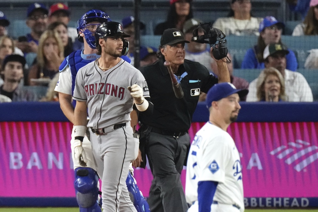 Arizona Diamondbacks' Blaze Alexander, second from left, tosses his bat after hitting a two-run home run as Los Angeles Dodgers catcher Will Smith, left, and starting pitcher Blake Snell, right, watch during the XX inning of a baseball game Friday, Aug. 29, 2025, in Los Angeles. (AP Photo/Mark J. Terrill)