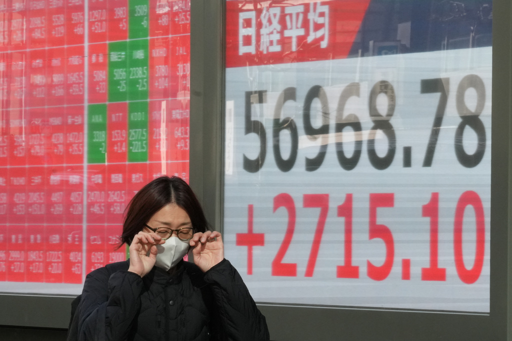 A person walks in front of an electronic stock board showing Japan's Nikkei index at a securities firm, Monday, Feb. 9, 2026, in Tokyo. (AP Photo/Eugene Hoshiko)
