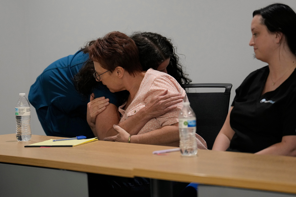 Lisa Emery, director of the New River Health Association Black Lung Clinic, left, hugs Delisa Legg, a black Lung benefits counselor at Rainelle Medical Center, during a Fayette County Black Lung Association meeting, Sept. 16, 2025, in Oak Hill, W.Va. (AP Photo/Carolyn Kaster)