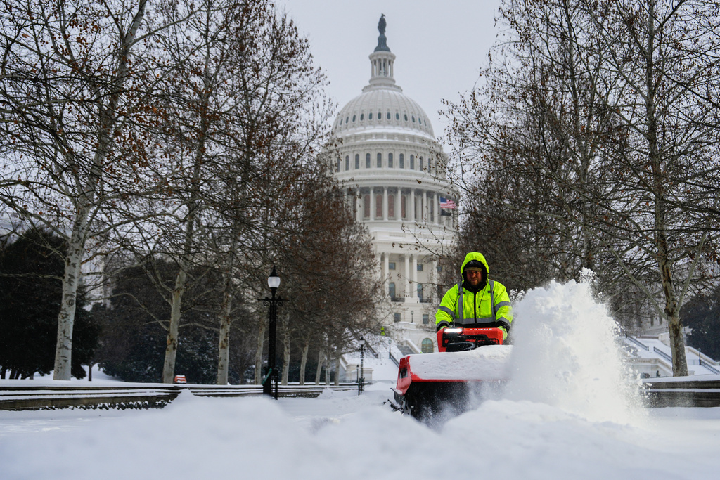 Architect of the Capitol workers clear snow outside the U.S. Capitol, Sunday, Jan. 25, 2026, in Washington. (AP Photo/Julia Demaree Nikhinson)