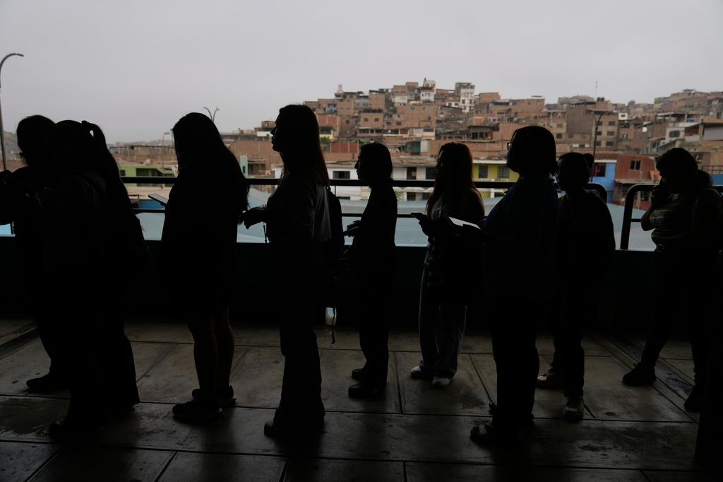 Voters line up as voting resumes at a polling stations affected by delays during general elections in Lima, Peru, Monday, April 13, 2026. (AP Photo/Martin Mejia)