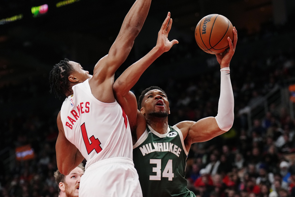 Milwaukee Bucks' Giannis Antetokounmpo (34) drives at Toronto Raptors' Scottie Barnes (4) during second half NBA basketball action in Toronto on Tuesday, Nov. 4, 2025. (Nathan Denette/The Canadian Press via AP)