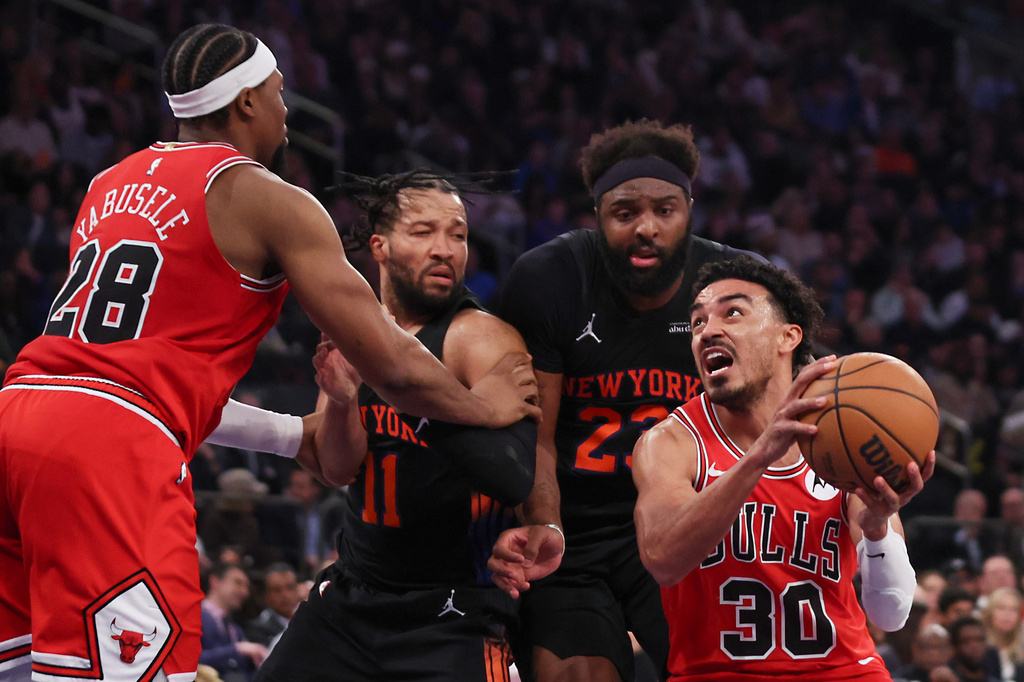 Chicago Bulls guard Tre Jones (30) drives to the basket past New York Knicks guard Jalen Brunson (11) and New York Knicks center Mitchell Robinson during the first half of an NBA basketball game, Friday, April 3, 2026, in New York. (AP Photo/Heather Khalifa)