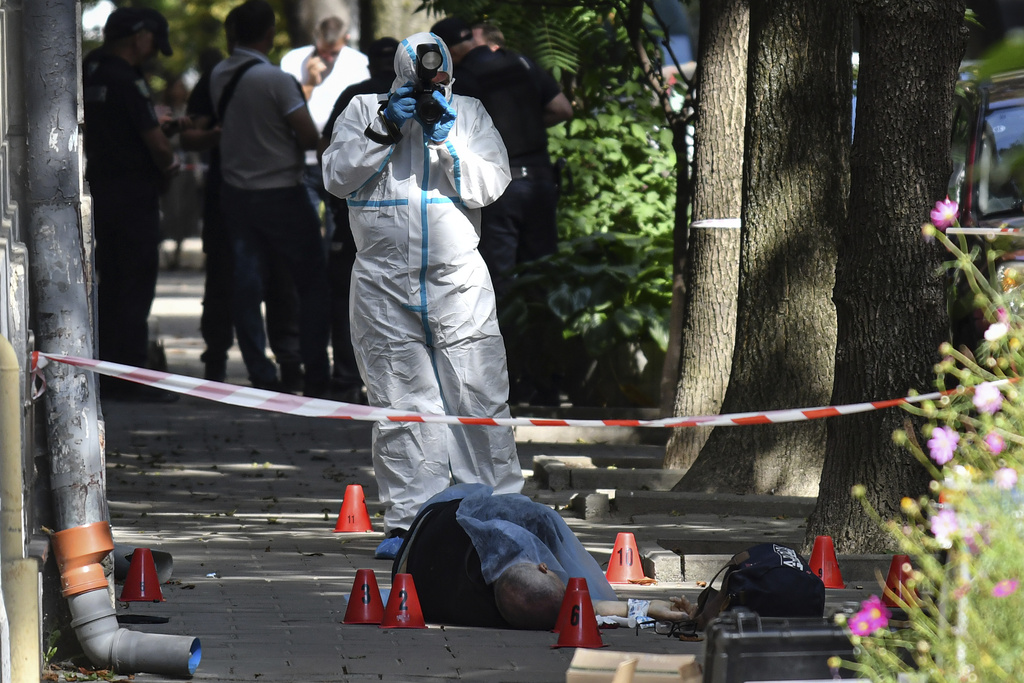 A forensic expert photographs a body of a former Ukrainian parliament speaker Andriy Parubiy, in Lviv, Ukraine, Saturday, Aug. 30, 2025. (AP Photo/Mykola Tys)