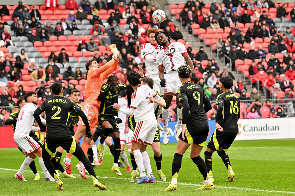 Toronto FC forward Josh Sargent, top left, and teammate forward Deandre Kerr, top right, head the ball on a corner kick against the Columbus Crew during the first half of an MLS soccer game in Toronto, Saturday, March 21, 2026. (Jon Blacker/The Canadian Press via AP)