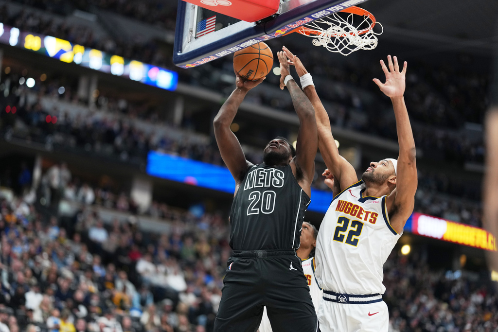 Denver Nuggets center Zeke Nnaji, right, goes up to block a shot by Brooklyn Nets center Day'ron Sharpe in the first half of an NBA basketball game Thursday, Jan. 29, 2026, in Denver. (AP Photo/David Zalubowski)