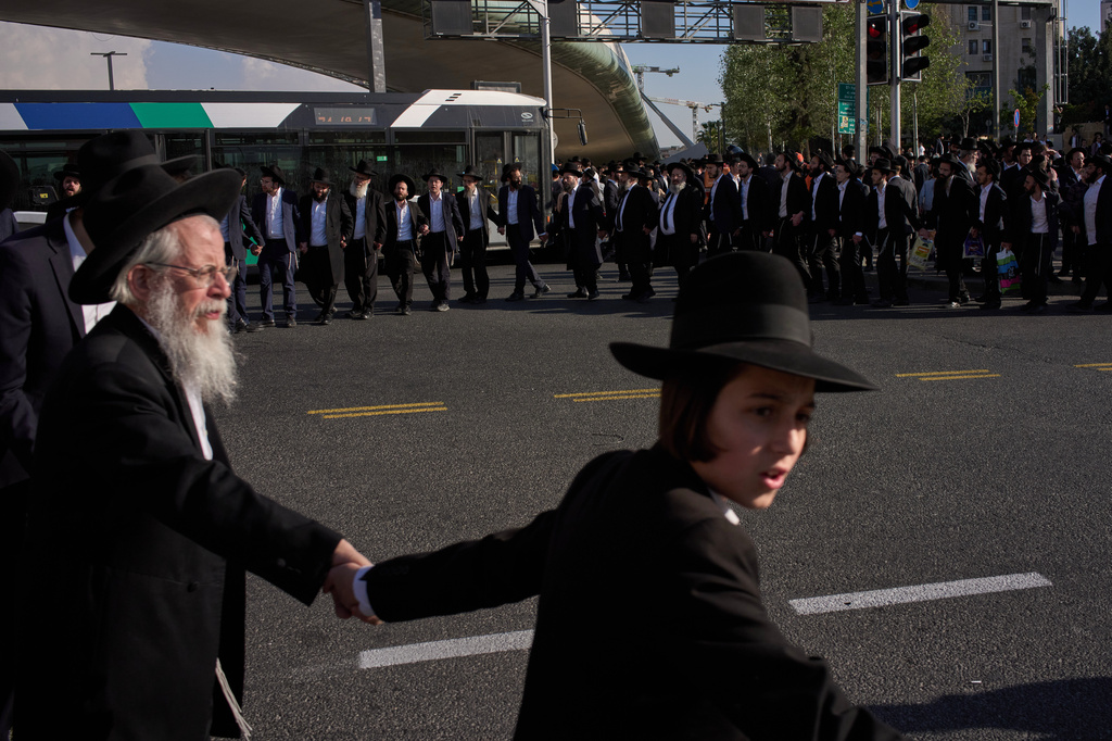 Ultra-Orthodox Jewish men block a road as they take part in a protest against army recruitment in Jerusalem, Wednesday, April 29, 2026. (AP Photo/Leo Correa)