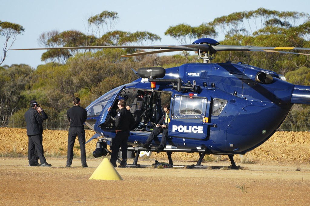 Police wait by a helicopter in Beacon, Western Australia, Friday, July 11, 2025, as they prepare to search for missing German backpacker Carolina Wilga. (ABC News via AP)