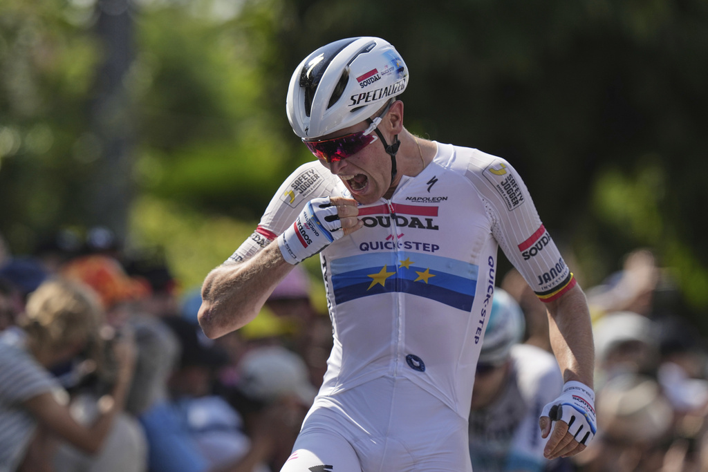 Stage winner Belgium's Tim Merlier celebrates as he crosses the finish line of the ninth stage of the Tour de France cycling race over 174.1 kilometers (108 miles) with start in Chinon and finish in Chateauroux, France, Sunday, July 13, 2025. (AP Photo/Thibault Camus)