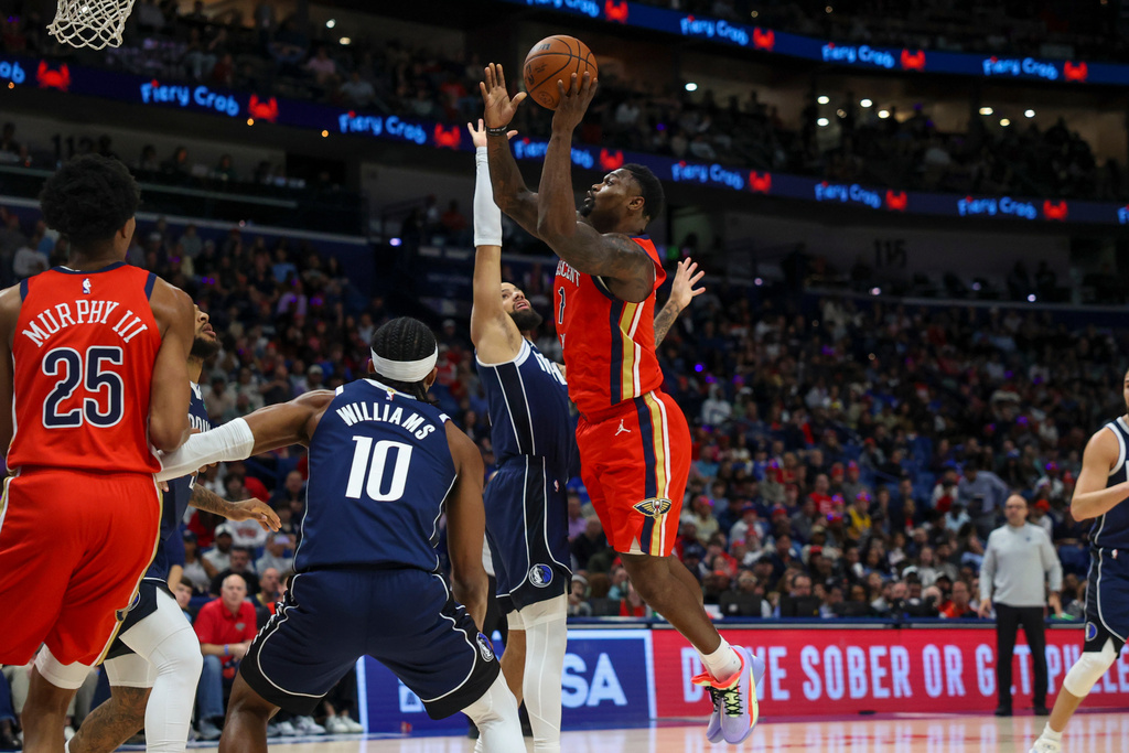 New Orleans Pelicans forward Zion Williamson (1) shoots a layup against Dallas Mavericks forward Daniel Gafford, left, in the first half of an NBA basketball game Monday, Dec. 22, 2025, in New Orleans. (AP Photo/Peter Forest)