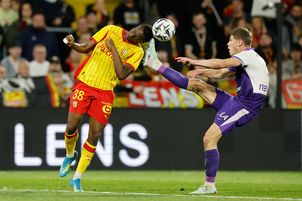 Lens' Rayan Fofana, left, and Toulouse's Charlie Cresswell fight for the ball during a League One soccer match between Lens and Toulouse in Lens, France, Friday, April 17, 2026. (AP Photo/Jean-Francois Badias)