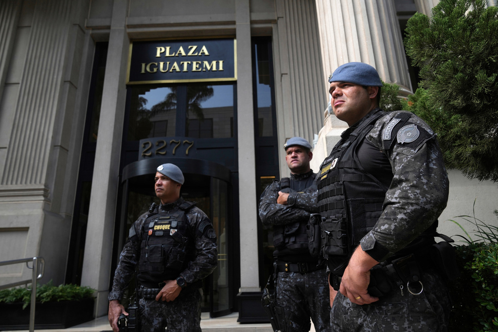 Police stand guard in front of a building during an operation investigating investment funds and the fuel sector, on Avenida Faria Lima, in Sao Paulo, Thursday, Aug. 28, 2025. (AP Photo/Andre Penner)