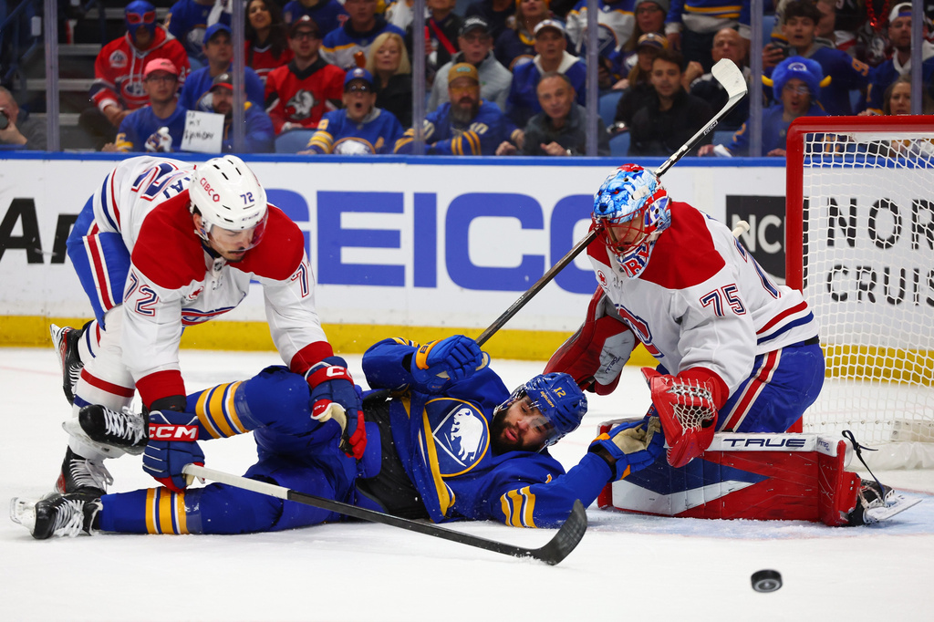 Buffalo Sabres left wing Jordan Greenway (12) is checked to the ice by Montreal Canadiens defenseman Arber Xhekaj (72) in front of goaltender Jakub Dobes (75) during the first period in Game 5 of a second-round NHL hockey Stanley Cup playoff series, Thursday, May 14, 2026, in Buffalo, N.Y. (AP Photo/Jeffrey T. Barnes)