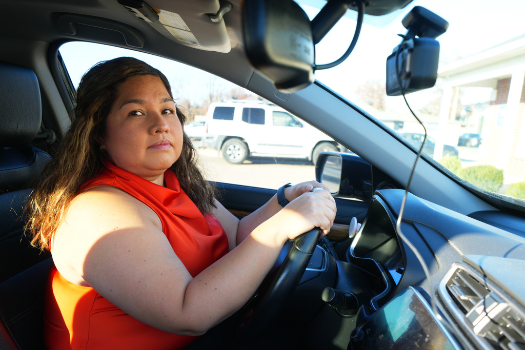 Immigration attorney Lilia Pacheco poses for a photo in her vehicle, which has a surveillance camera she installed on the windshield in order to record interactions with police should she be pulled over, Nov. 18, 2025, in Rogers, Ark. (AP Photo/Julio Cortez)