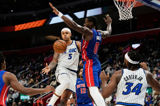Orlando Magic forward Paolo Banchero (5) passes to center Wendell Carter Jr. (34) while under pressure from Detroit Pistons center Jalen Duren (0) during the first half of an NBA basketball game Wednesday, Oct. 29, 2025, in Detroit. (AP Photo/Ryan Sun) Orlando Magic forward Paolo Banchero (5) passes to center Wendell Carter Jr. (34) while under pressure from Detroit Pistons center Jalen Duren (0) during the first half of an NBA basketball game Wednesday, Oct. 29, 2025, in Detroit. (AP Photo/Ryan Sun)