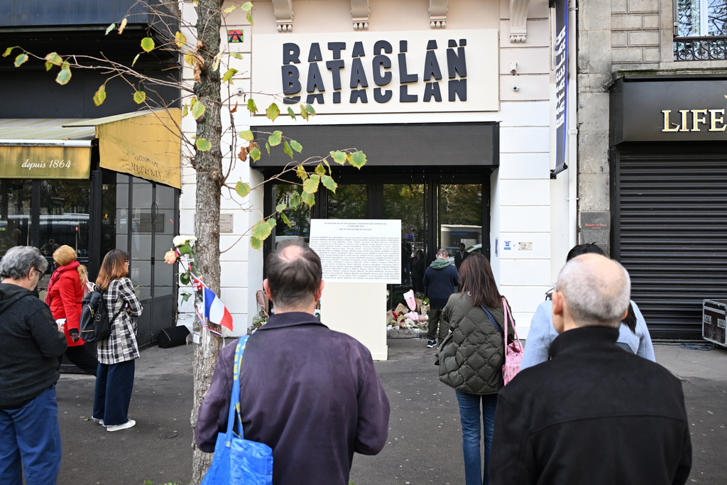 People pay their respects to victims in front of the Bataclan concert hall as Paris is marking the 10th anniversary of terrorist attacks that killed 132 people and injured hundreds, Thursday, Nov. 13, 2025 in Paris. (AP Photo/Emma Da Silva)