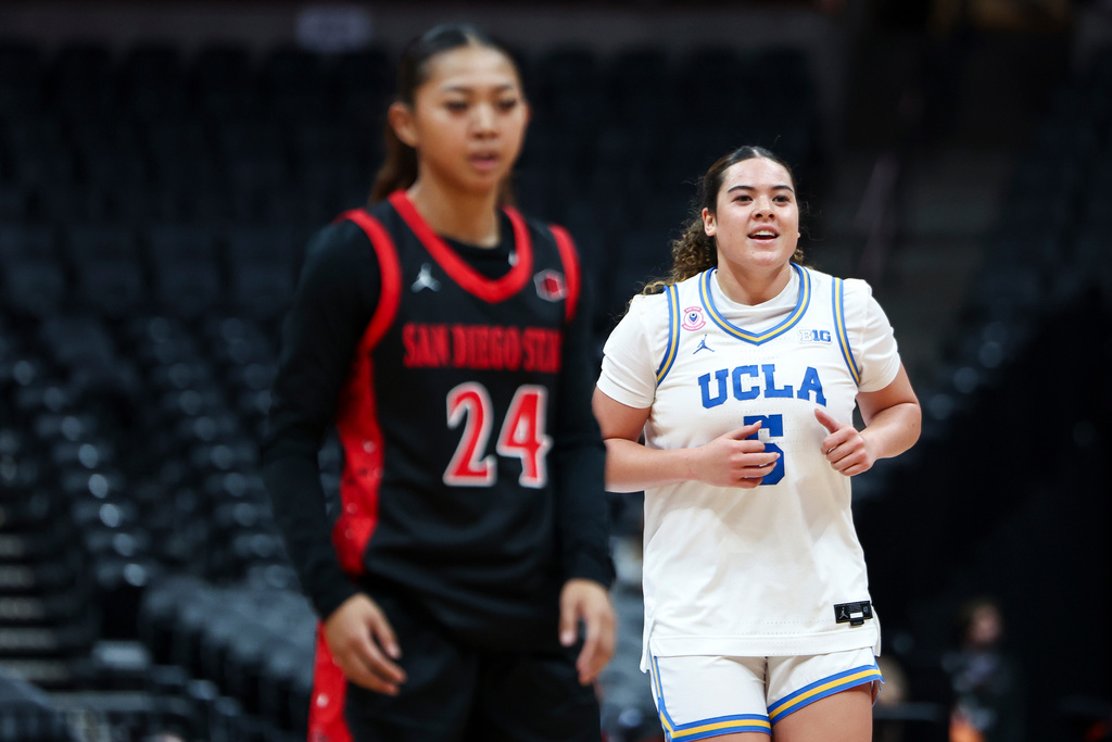 UCLA guard Charlisse Leger-Walker (5) reacts after a 3-point basket as San Diego State guard Naomi Panganiban (24) looks on during the first half of an NCAA college basketball game Monday, Nov. 3, 2025, in Anaheim, Calif. (AP Photo/Jessie Alcheh)