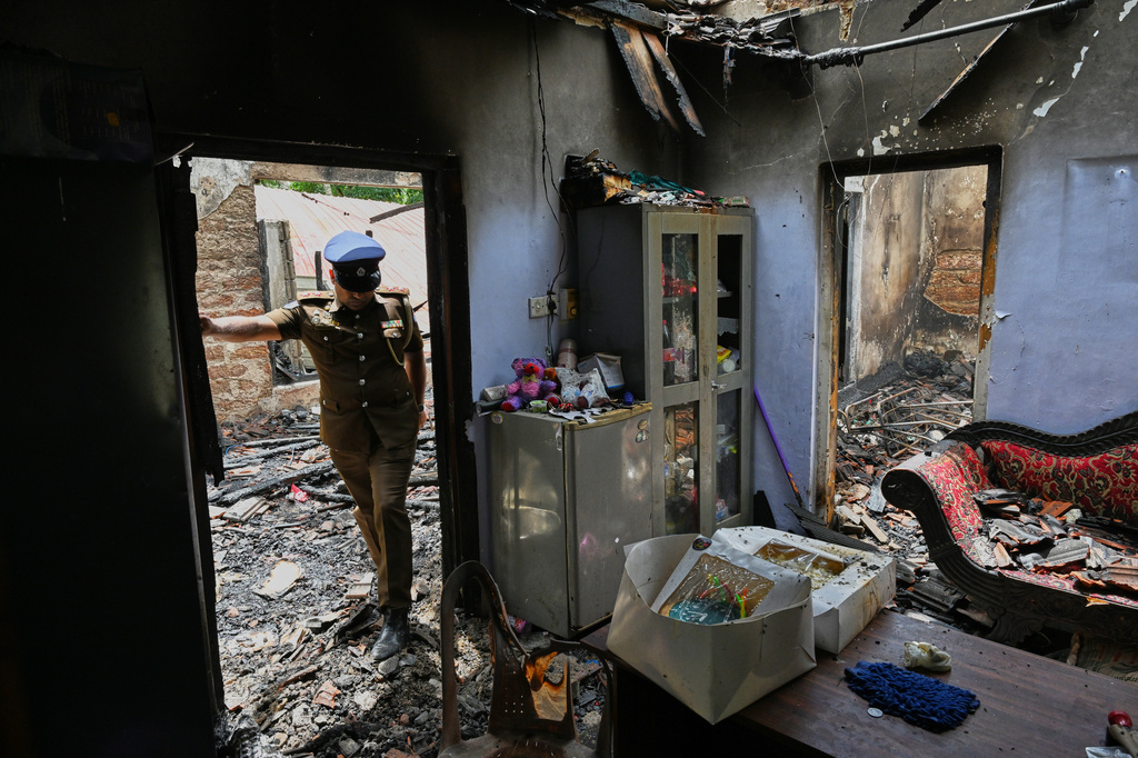 A Sri Lankan police officer inspects a charred elderly care home following an overnight fire in Anguruwatota, Sri Lanka, Thursday, June 4, 2026. (AP Photo)