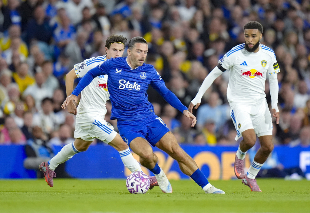 From left to right, Leeds United's Brenden Aaronson, Everton's Jack Grealish and Leeds United's Jayden Bogle battle for the ball during an English Premier League soccer match between Leeds United and Everton at Elland Road in Leeds, England, Monday, Aug. 18, 2025. (Danny Lawson/PA via AP)
