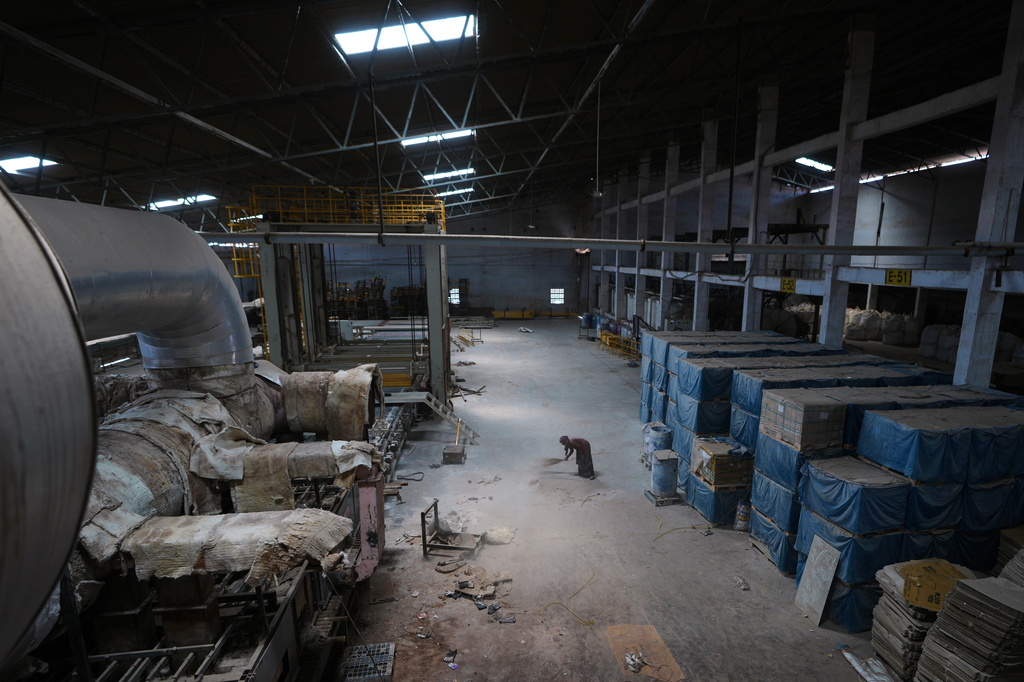 A worker sweeps the floor of a closed ceramics factory in Morbi,in the Indian state of Gujarat, Wednesday, April 8, 2026. (AP Photo/Ajit Solanki)