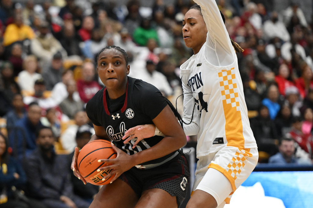 South Carolina guard Ta'niya Latson, left, drives to the basket as Coppin State guard Khila Morris, right, defends during the first half of an NCAA college basketball game Sunday, Jan. 18, 2026, in Baltimore. (AP Photo/Gail Burton)